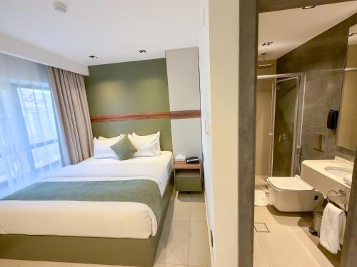 亚喀巴Coral Beach Hotel & Spa的一间带床和浴室的酒店房间