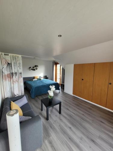 a living room with a bed and a couch at Le Pigeonnier in Dombresson