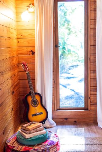 a guitar sitting on a table next to a pile of books at Kanimbia Cottages in Coolabine