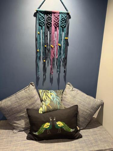 a bunch ofaments hanging on a wall above a bed at The Ship Inn's Mill Cottage - Weavers Way in Gatehouse of Fleet