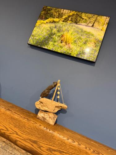 a picture hanging on a wall next to a wooden bench at The Ship Inn's Mill Cottage - Weavers Way in Gatehouse of Fleet