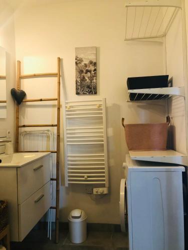 a kitchen with a sink and a refrigerator and shelves at Bel Air Studios-Terrasse couverte-Jardinet-Vue Pont de Normandie-Parking privé in Honfleur