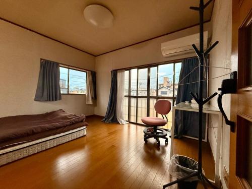 een slaapkamer met een bed en een stoel in een kamer bij 桜の家 in Saitama
