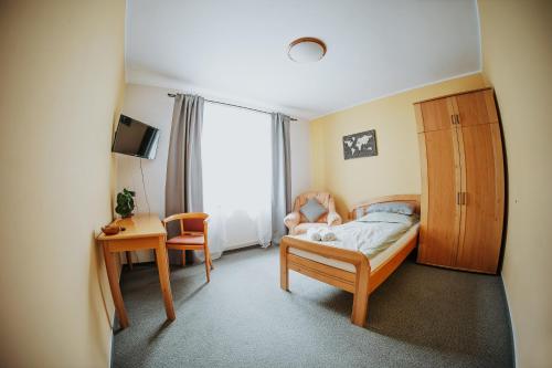 新伊钦乌兹沃努旅馆的一间卧室配有一张床、一张桌子、一张床和一把椅子