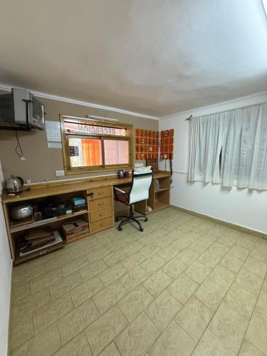 an office with a desk and a chair in a room at HOTEL Y RESTAURANTE CAñADON LEON in Gobernador Gregores