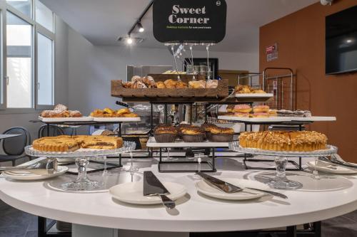 a table with many different types of pastries and cakes at B&B HOTEL Sassari in Sassari