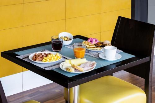 B&B HOTEL Bari Rondò في باري: صينية الإفطار مع طعام الإفطار على الطاولة