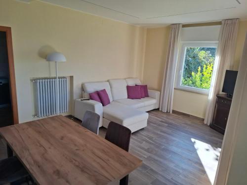 a living room with a white couch and a table at Madonna Dell'Aiuto True View Olivo in Brenzone sul Garda