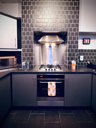a kitchen with a stove top oven in a kitchen at The Duff 1 Bed Flat Walk to Marina Shops and Train in Bangor