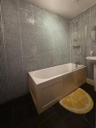a bathroom with a bath tub and a sink at The Duff 1 Bed Flat Walk to Marina Shops and Train in Bangor
