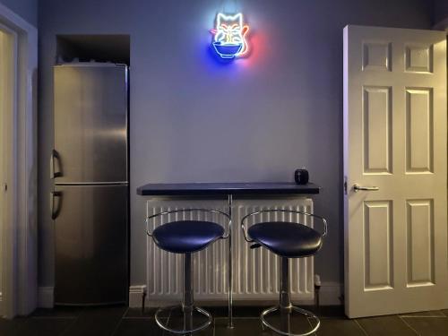 班戈北爱尔兰The Duff 1 Bed Flat Walk to Marina Shops and Train的厨房设有带2张凳子和冰箱的酒吧