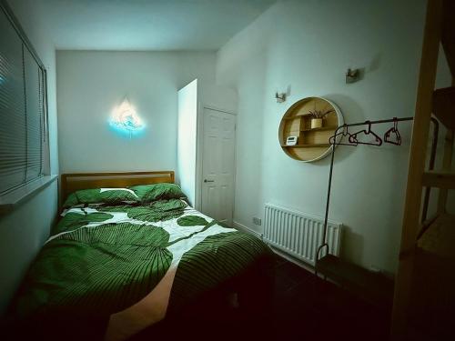 a small bedroom with a bed and a mirror at The Duff 1 Bed Flat Walk to Marina Shops and Train in Bangor