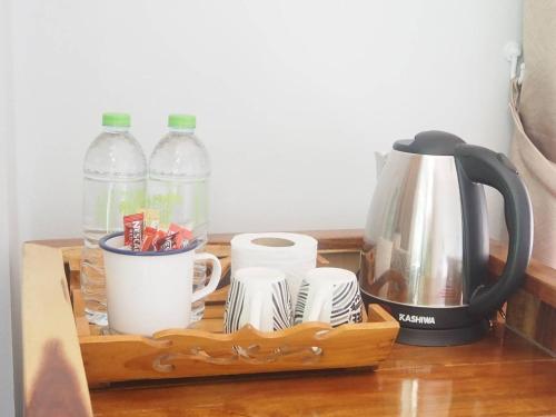 un vassoio di legno con tazze e bottiglie d'acqua su un tavolo di Mookies Bungalows a Ko Mook