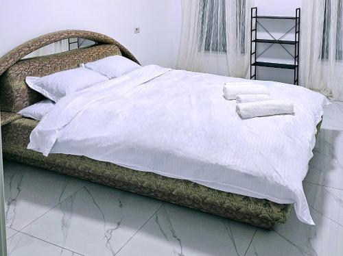 a bed with white sheets and towels on it at Casa in Şimnicu de Jos