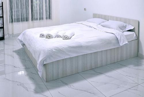 a white bed with two stuffed animals on it at Casa in Şimnicu de Jos