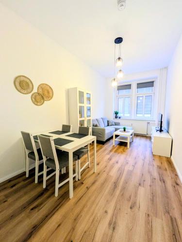 ein Wohnzimmer mit Tisch und Stühlen und einer Couch in der Unterkunft AltstadtQuartier Bautzen in Bautzen
