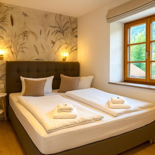 a bedroom with a large bed with towels on it at Hotel garni Königslinde - Wandern, Radeln, Skifahren & Genießen in Bayrischzell