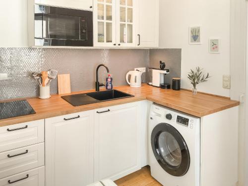 eine Küche mit Waschmaschine und Spüle in der Unterkunft Charmante, ruhige Wohnung im Herzen der Altstadt von Heidelberg in Heidelberg
