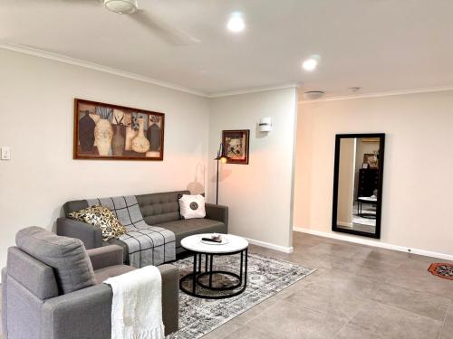 a living room with a couch and a table at Cozy Family Home at Loganholme in Loganholme