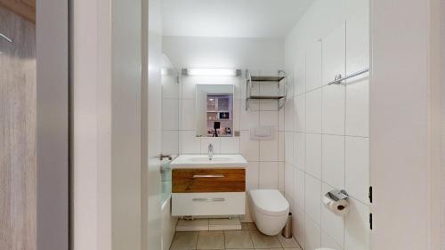 ein kleines Badezimmer mit Waschbecken und Toilette in der Unterkunft Gemütliche Studios in Davos - Bergblick & zentrale Lage in Davos