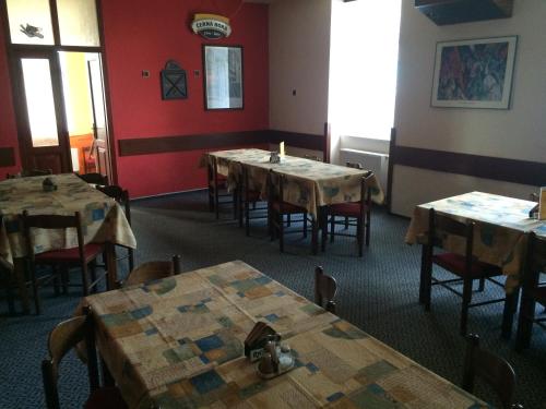 a dining room with wooden tables and red walls at Hotel Filippi in Ždírec nad Doubravkou