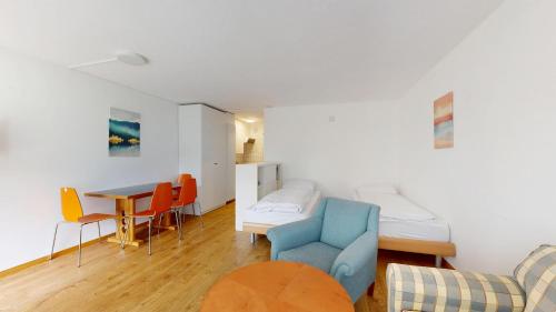 ein Zimmer mit einem Bett und einem Tisch und Stühlen in der Unterkunft Gemütliche Studios in Davos - Bergblick & zentrale Lage in Davos