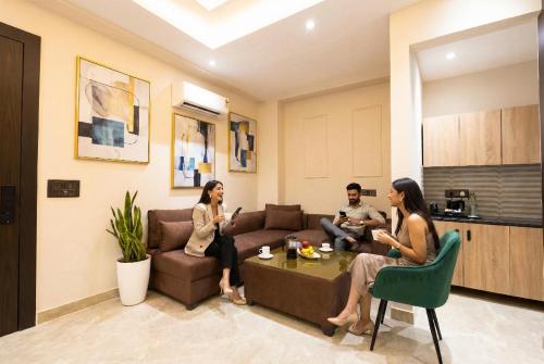 eine Gruppe von Menschen sitzt in einem Wohnzimmer in der Unterkunft Leaf 9 Grand, Near Udyog vihar and Yashobhoomi in Gurgaon
