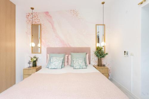 a bedroom with a bed with pink and blue pillows at New! Sea View Apartment with Aircon in Center of Las Americas in Playa de las Americas