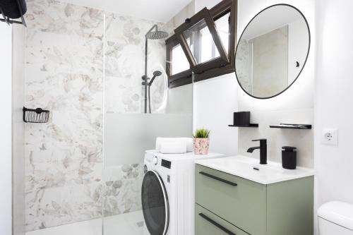 a bathroom with a washing machine and a mirror at New! Sea View Apartment with Aircon in Center of Las Americas in Playa de las Americas