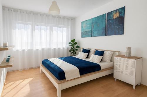 Un dormitorio con una cama grande con sábanas azules y blancas. en Cozy M3 at Pojezierska Street, en Łódź