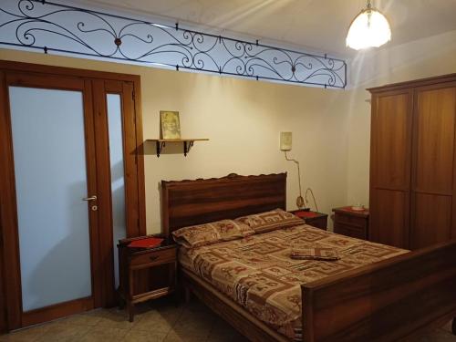 una camera da letto con un letto con testiera in legno di Da Katy a Mondovì