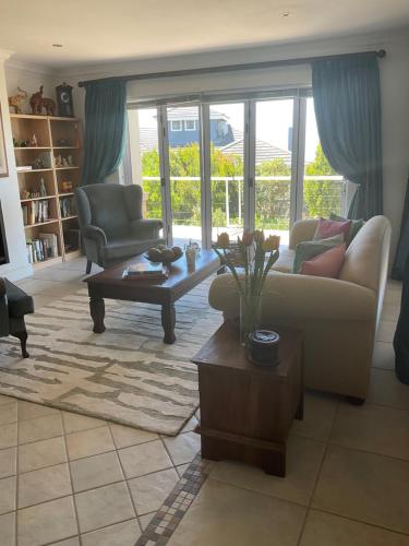 a living room with a couch and a coffee table at Hill Top Guesthouse in Plettenberg Bay