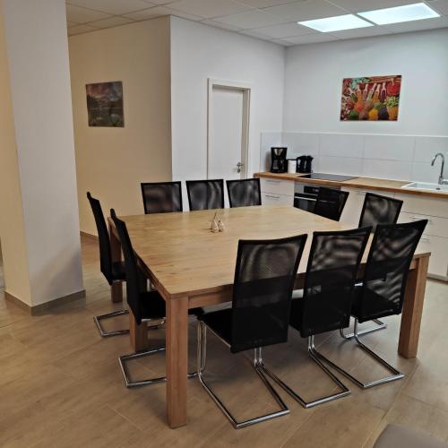 a conference room with a wooden table and chairs at Eleonoras Ferienwohnung in Würzburg Stadt mit Terrasse und eigenen Parkplätzen vor der Tür, für große Gruppen bis zu 13 Personen geeignet in Würzburg