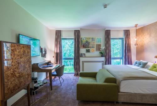 a hotel room with a bed and a desk and a desk at Park Villa Hotel in Wuppertal
