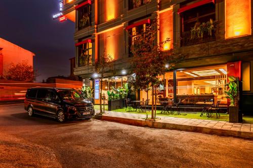 a car parked in front of a building at night at Elysian Airport Hotel & Restaurant in Arnavutköy