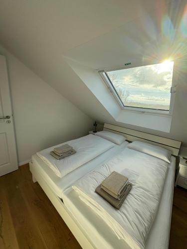 a white bed in a room with a window at Gulfhof Wangermeer 2 Tilda in Hohenkirchen