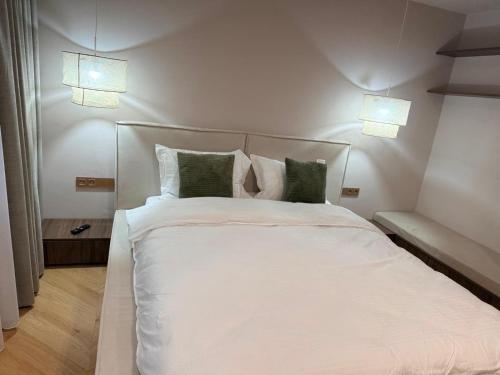 a bedroom with a white bed with green pillows at Vega Luxury & Relax House in Orşova