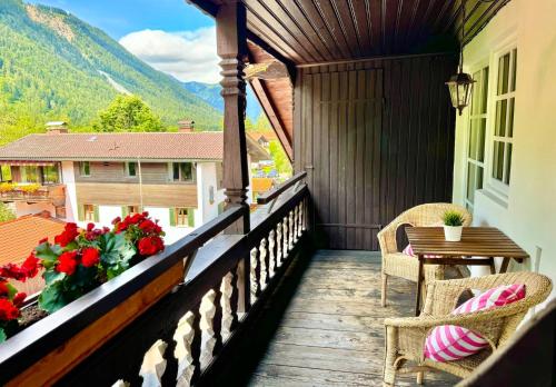 ein Balkon mit Stühlen, einem Tisch und Blumen in der Unterkunft Hotel garni Königslinde - Wandern, Radeln, Skifahren & Genießen in Bayrischzell