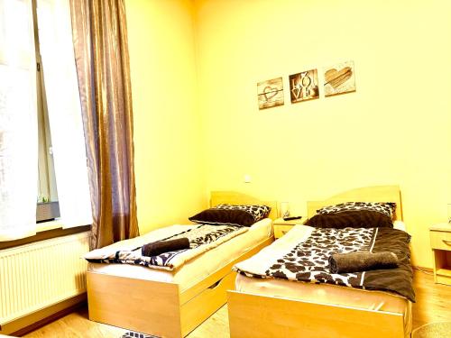 two beds sitting in a room with a window at Oasis Valley in Karlovy Vary