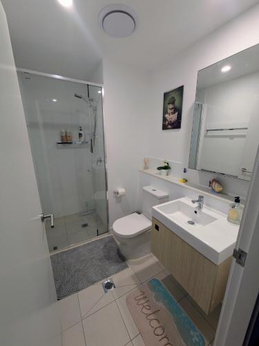 a bathroom with a toilet and a sink and a shower at Bedroom with Private Bathroom in cozy shared appartment! in Brisbane