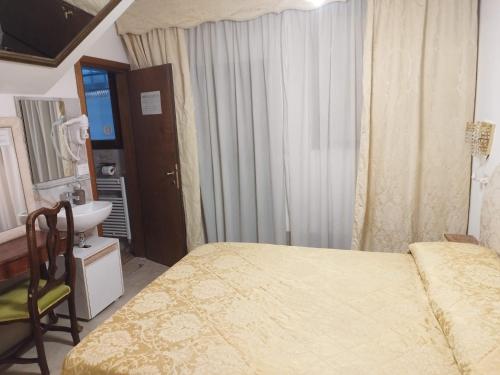 威尼斯Alloggi Acquavita - checkin at "Alloggi SS Giovanni e Paolo"的带床、水槽和镜子的卧室