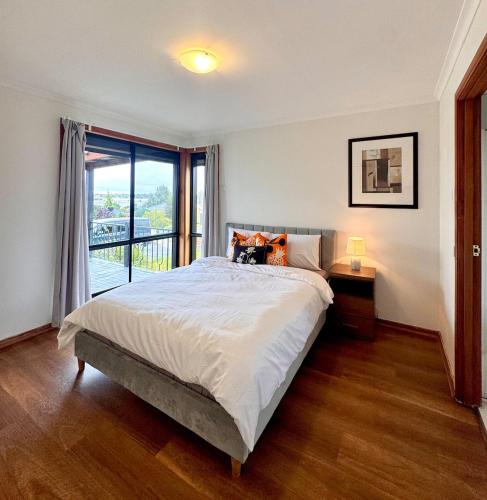 a bedroom with a large bed and a balcony at Comfortable 2BR Home in Hallam in Hallam