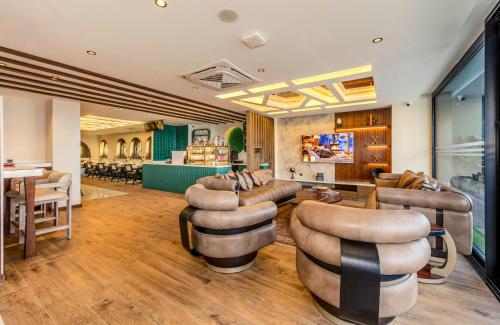una hall con divani e sedie e un bar di Elysian Airport Hotel & Restaurant a Arnavutköy