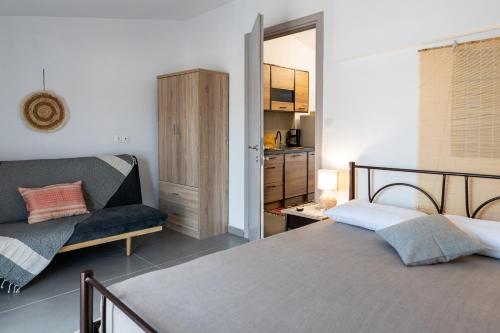 a bedroom with a bed and a couch at Dore Appartments in Nea Fokea