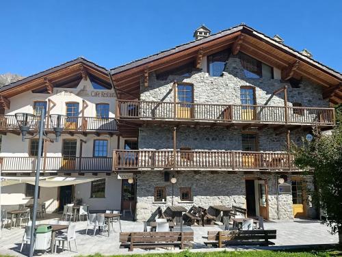 La Tour في Oyace: مبنى حجري كبير به شرفات وطاولات