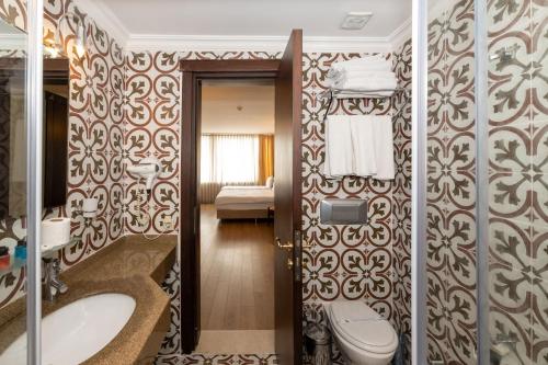 a bathroom with a toilet and a sink at Taksim Pera Rose Hotel & Spa - Istiklal Street in Istanbul