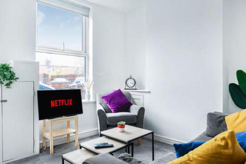 a living room with a tv and a couch at Sleek 2BR city centre Pool table, Parking, Garden, Workspace, weekly sale in Nottingham