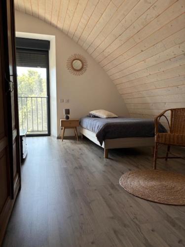 Un dormitorio con una cama en una habitación con ventana. en Gîte Auberoques Aveyron- maison indépendante- classée 3 étoiles, en Les Fonds