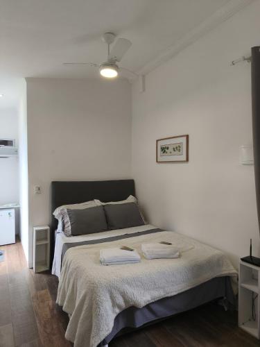a bedroom with a bed with two towels on it at Suíte privativa Vila Dom Pedro in Paraty