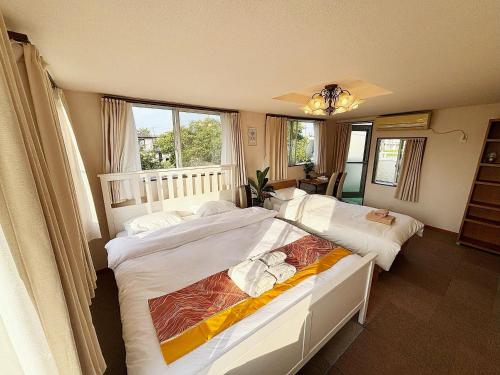 a bedroom with two beds and a window at 九十九里シーサイドヴィラ in Tōganemachi